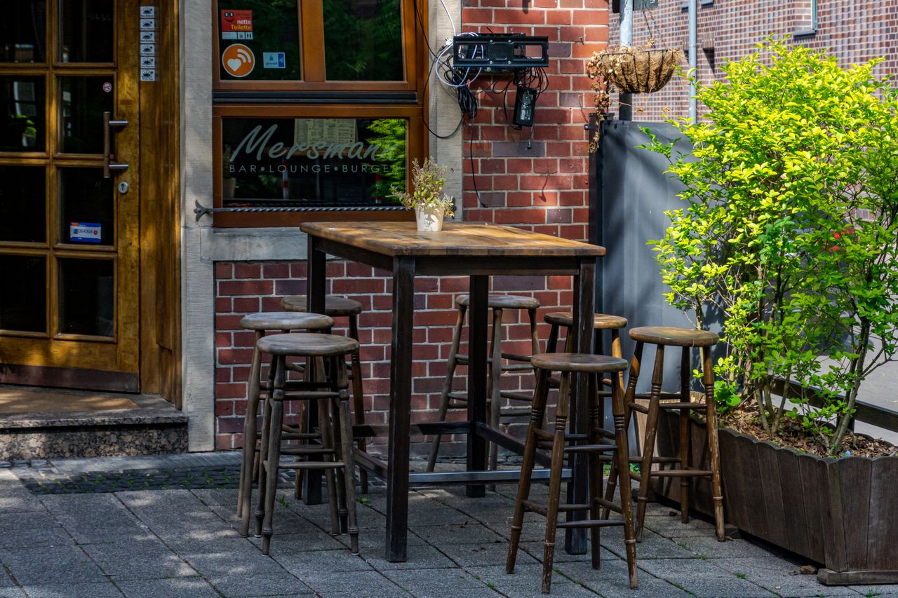 Cozy outdoor seating at a bar and lounge in Coesfeld, Germany, under warm daylight.